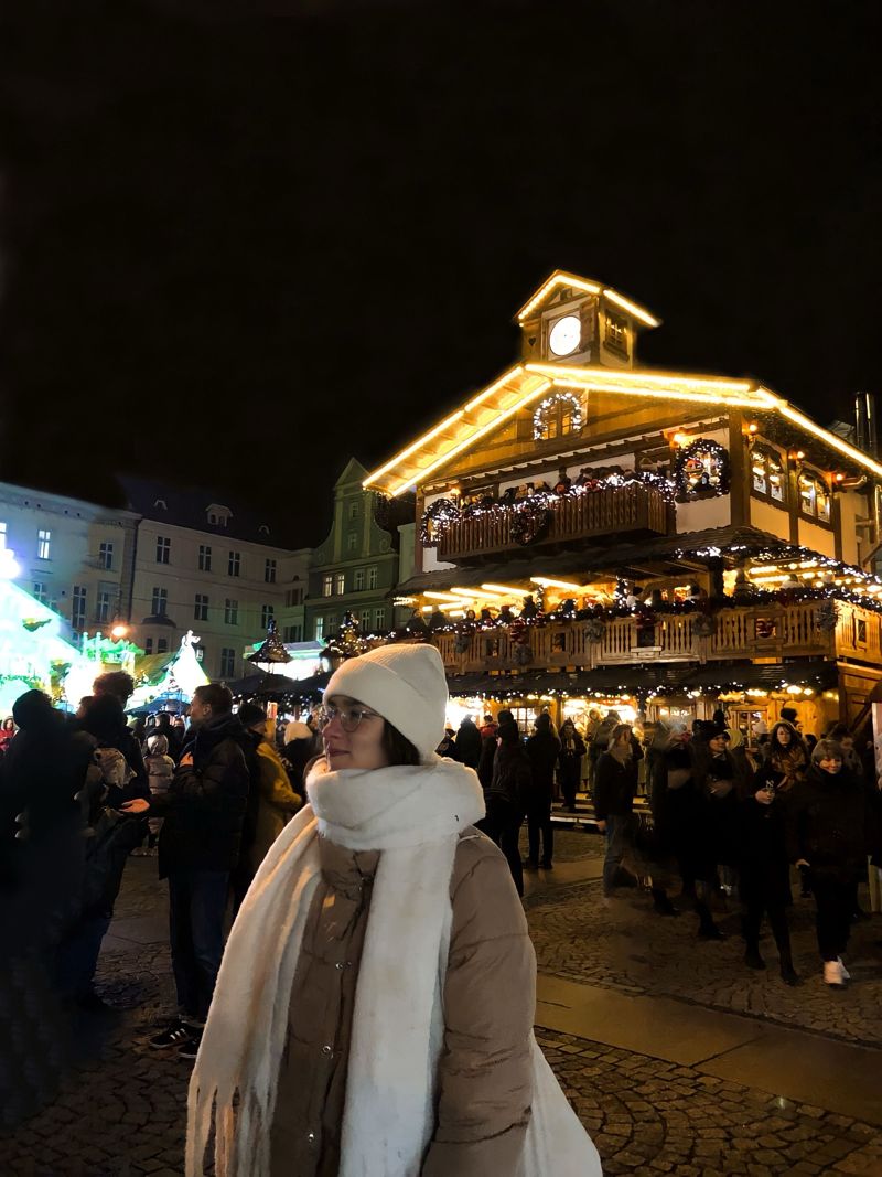 Marta no mercado de Natal iluminado de Wrocław, à noite